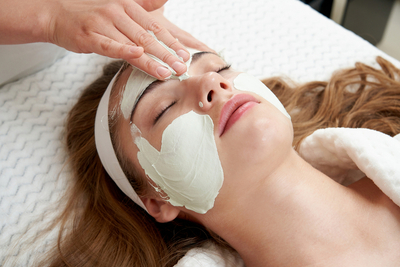 Cosmetologist applying an acid treatment mask to improve skin texture and tone.