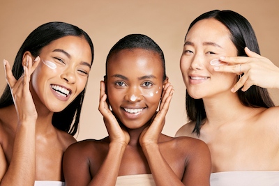 Portrait of three confident women with glowing skin, highlighting the importance of knowing your skin type.