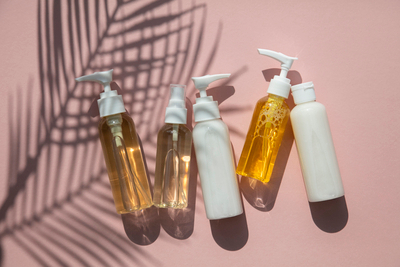 Skincare bottles on pink background — guide to 6 irritants to avoid for sensitive skin and gentler fragrance-free options.