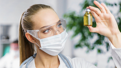 Scientist examining a vial of mineral oil used in skincare formulations
