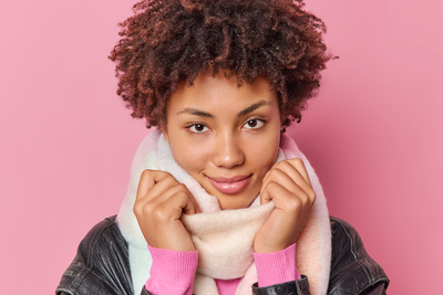 Young woman with healthy glowing skin wrapped in a warm scarf in winter, showing hydrated complexion and protected skin barrier